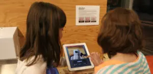 Two children use an iPad to record a frame of their animation