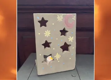 clay tile with cutout stars and a place for a tea light to create a luminary