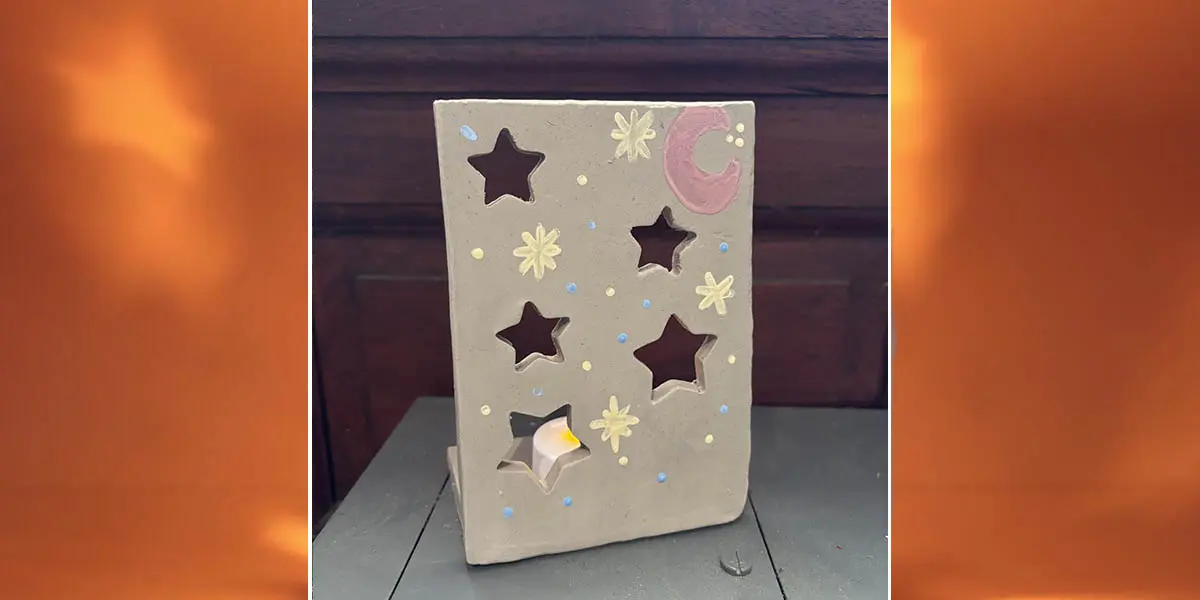 clay tile with cutout stars and a place for a tea light to create a luminary