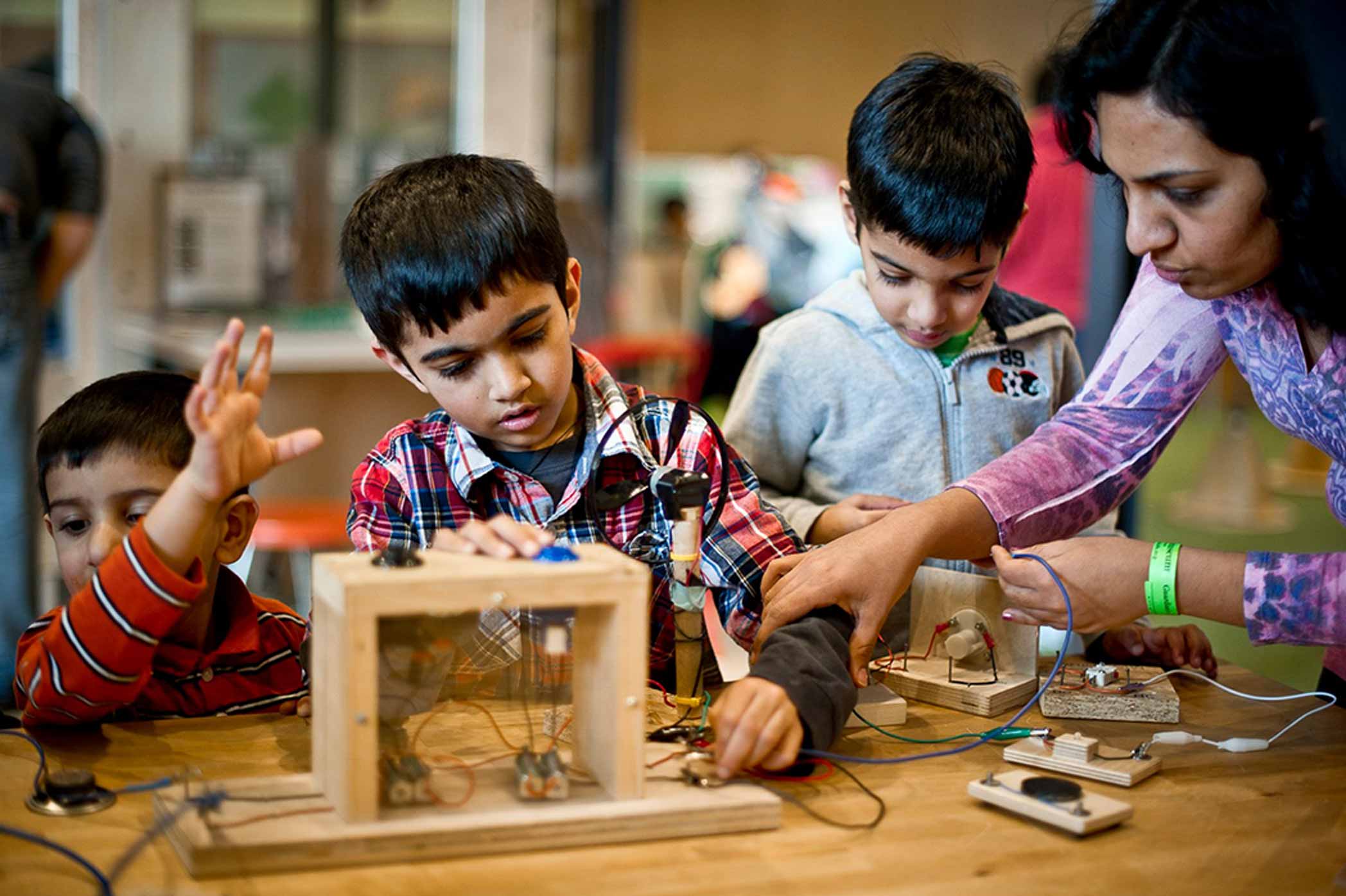 a mother and three young boys completing circuits in a workshop setting
