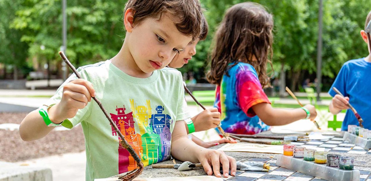 several children painting outside in summer