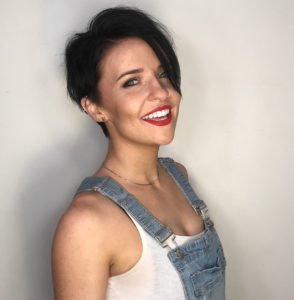 professional photo of artist Sarah Bowling, white woman in overalls and tank top