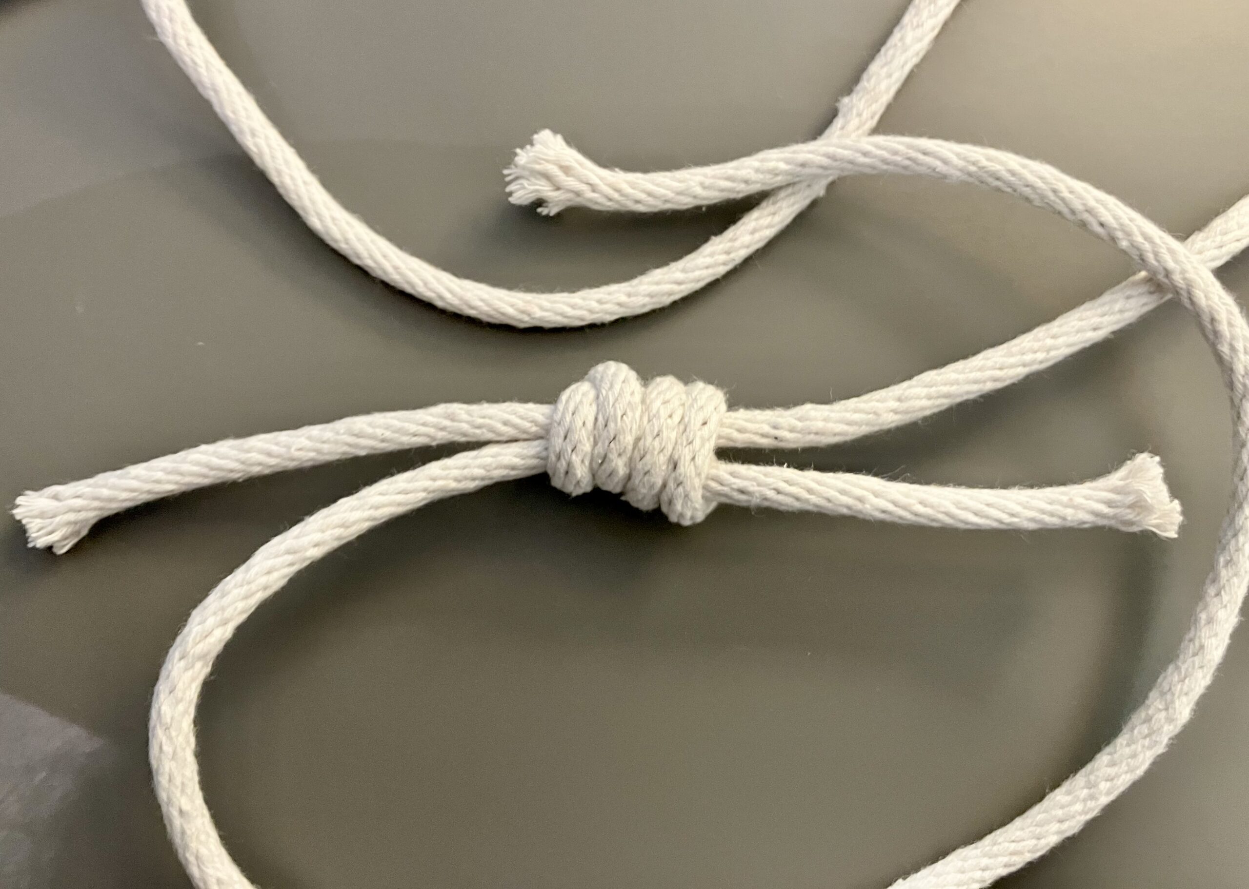 White rope is tied into a double fisherman's knot