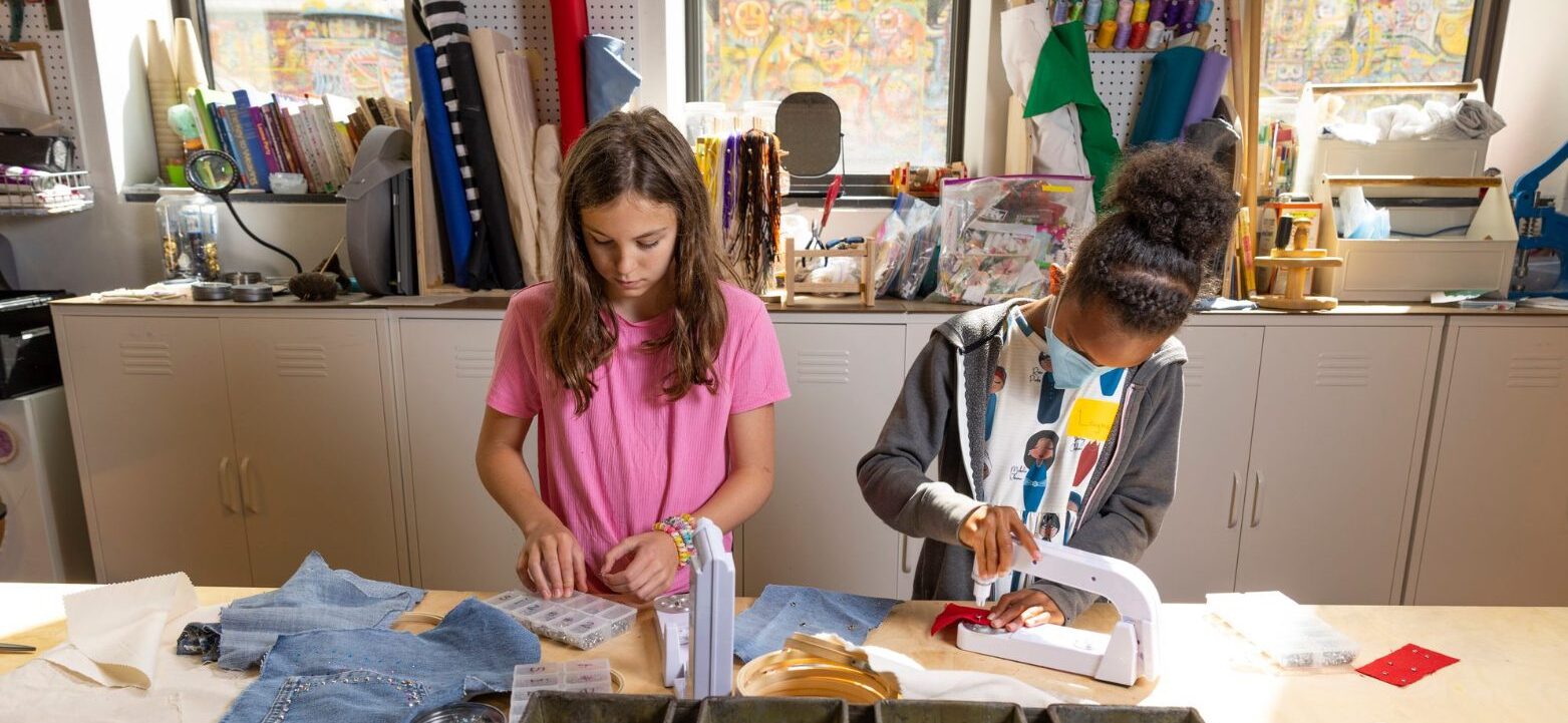 Two girls concentrating on their sewing projects