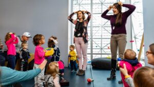 two women leading babies and toddlers in a singing and dancing program