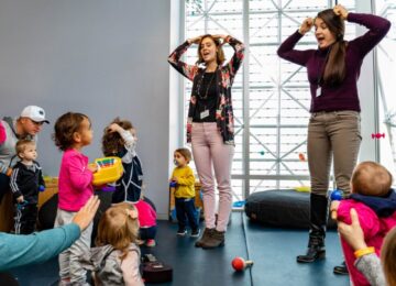two women leading babies and toddlers in a singing and dancing program