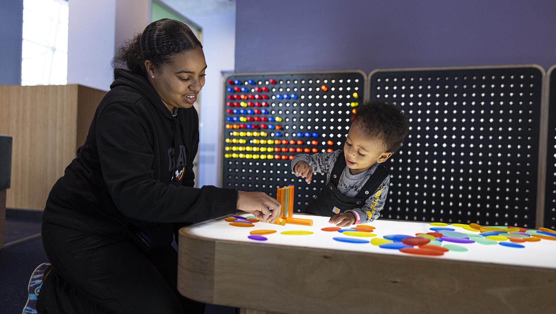 mother and young son at light table