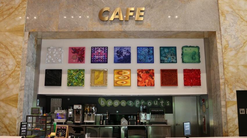 image of a series of colorful square artworks hung in a cafe above the ordering area