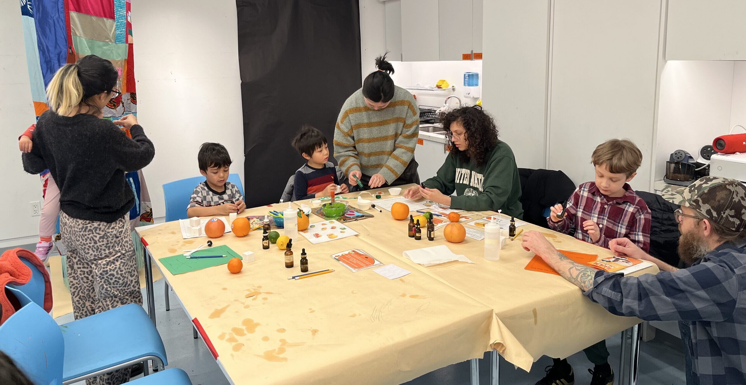 families working on a project with small bottles at a work table